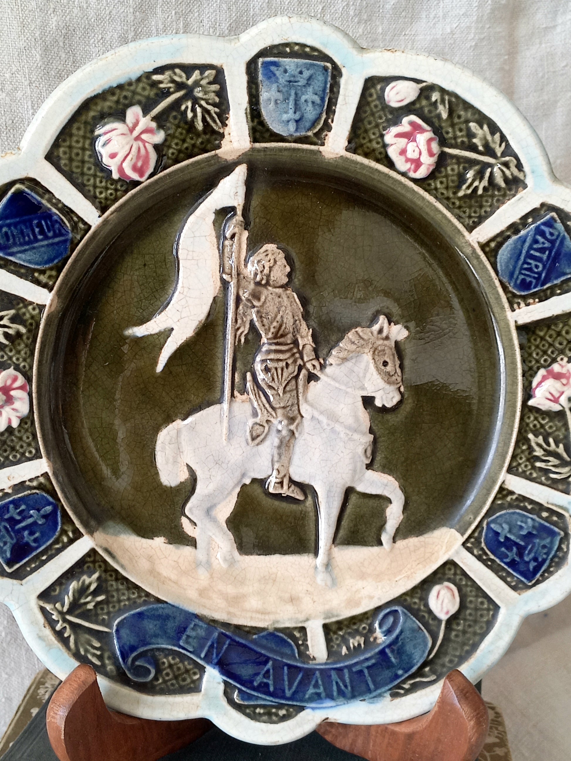 Decorative plate with a central figure of a knight on a horse, surrounded by floral and decorative elements.