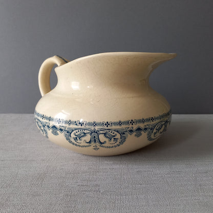 A beautiful French antique jug/pitcher, once used to pour water in a bowl for washing yourself, these days wonderful home decor - many people use them as bathroom decor.

This particular piece is in a lovely shade of off-white/cream with a dark blue transfer pattern - a very stylish and eye-catching piece of ironstone.