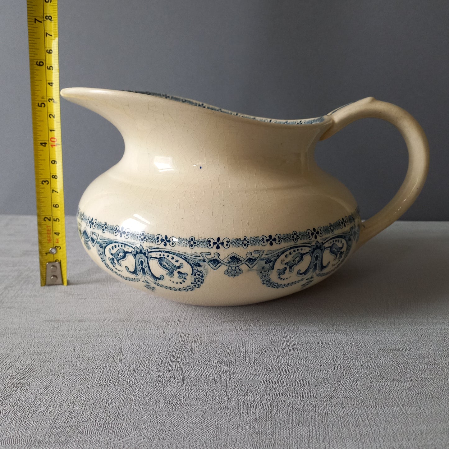 A beautiful French antique jug/pitcher, once used to pour water in a bowl for washing yourself, these days wonderful home decor - many people use them as bathroom decor.

This particular piece is in a lovely shade of off-white/cream with a dark blue transfer pattern - a very stylish and eye-catching piece of ironstone.