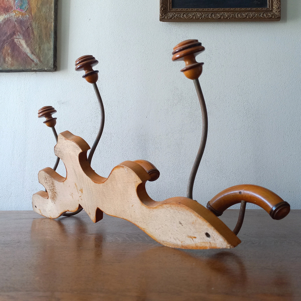 A stunning French vintage coat and hat rack with a decorative wooden wall-mounted rack holding 3 metal hooks, each hook having 2 turned wooden pegs for a hat and coat.

In summary a decorative and practical piece of vintage wall decor for any interior.