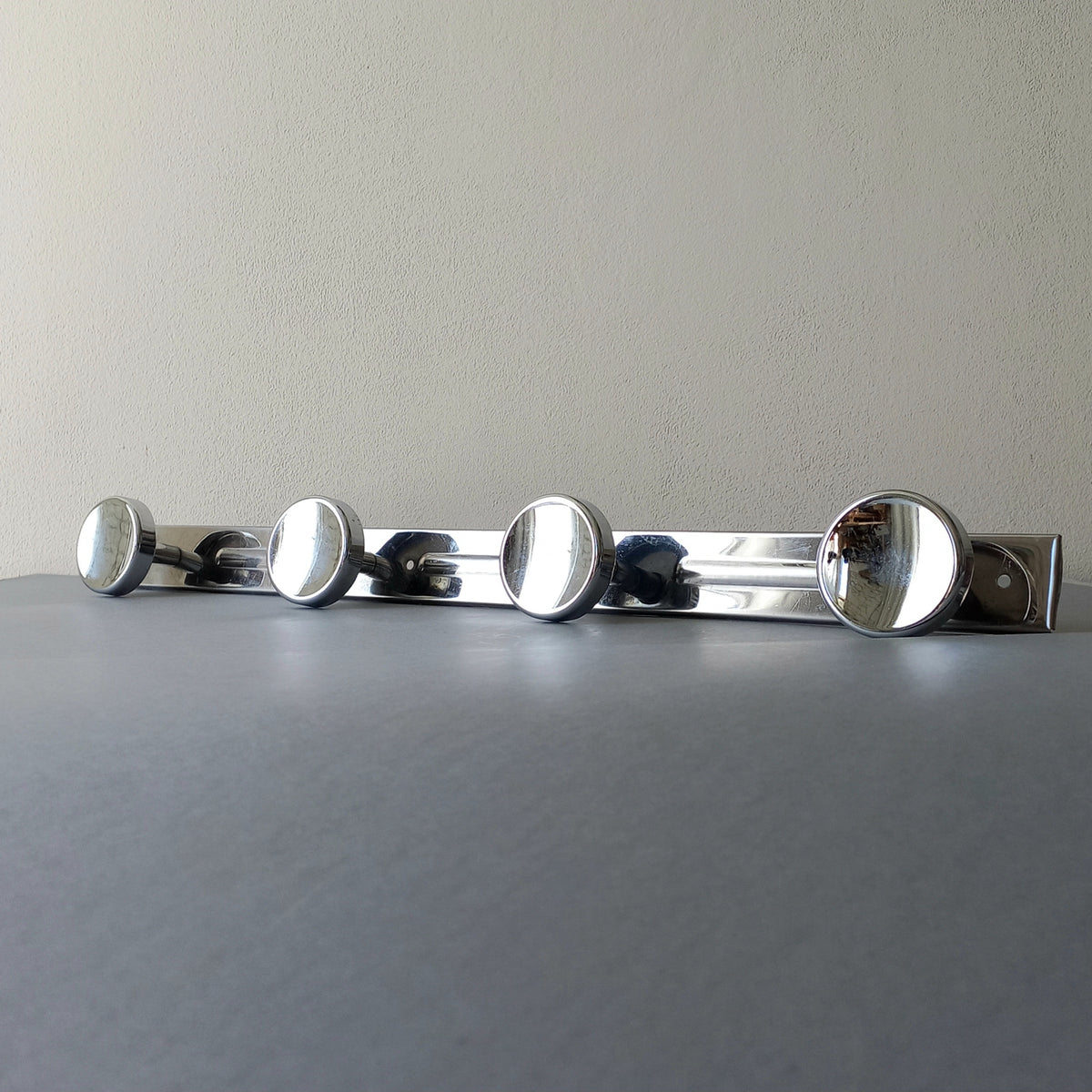 A stylish French vintage 4 peg metal coat rack with a polished finish, a great piece of practical wall decor for your home.