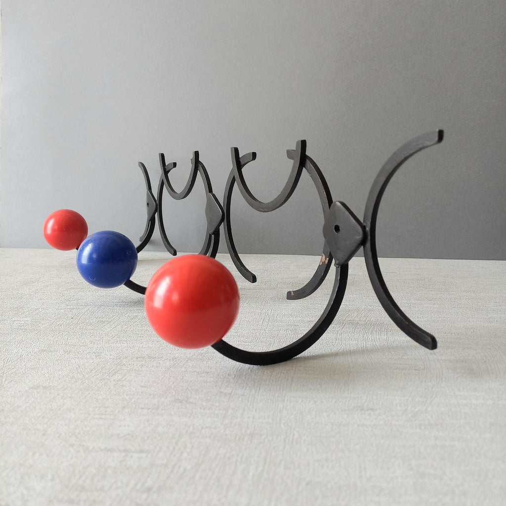 An original French vintage mid-century 'atomic' coat rack, a rare find these days and a wonderful piece of practical home decor. The black frame-work that holds the coloured pegs/balls is made from strong cast iron and there are two screw holes so that you can immediately fix the coat rack to your wall.