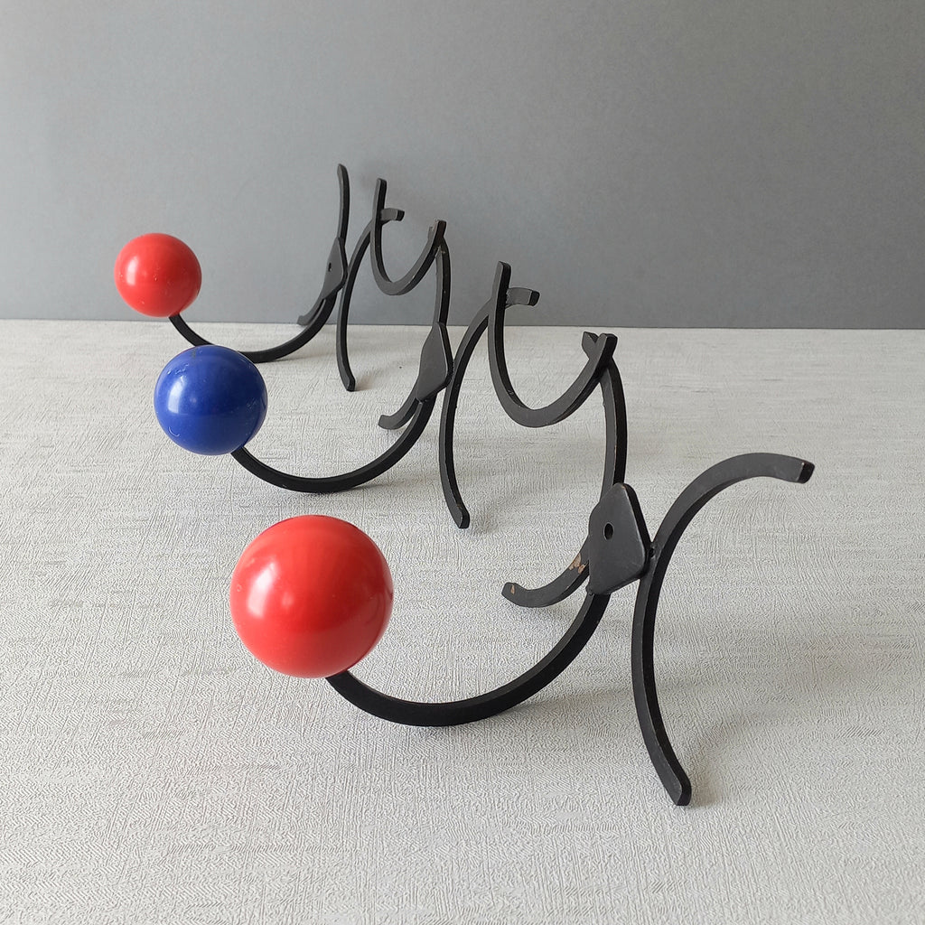 An original French vintage mid-century 'atomic' coat rack, a rare find these days and a wonderful piece of practical home decor. The black frame-work that holds the coloured pegs/balls is made from strong cast iron and there are two screw holes so that you can immediately fix the coat rack to your wall.