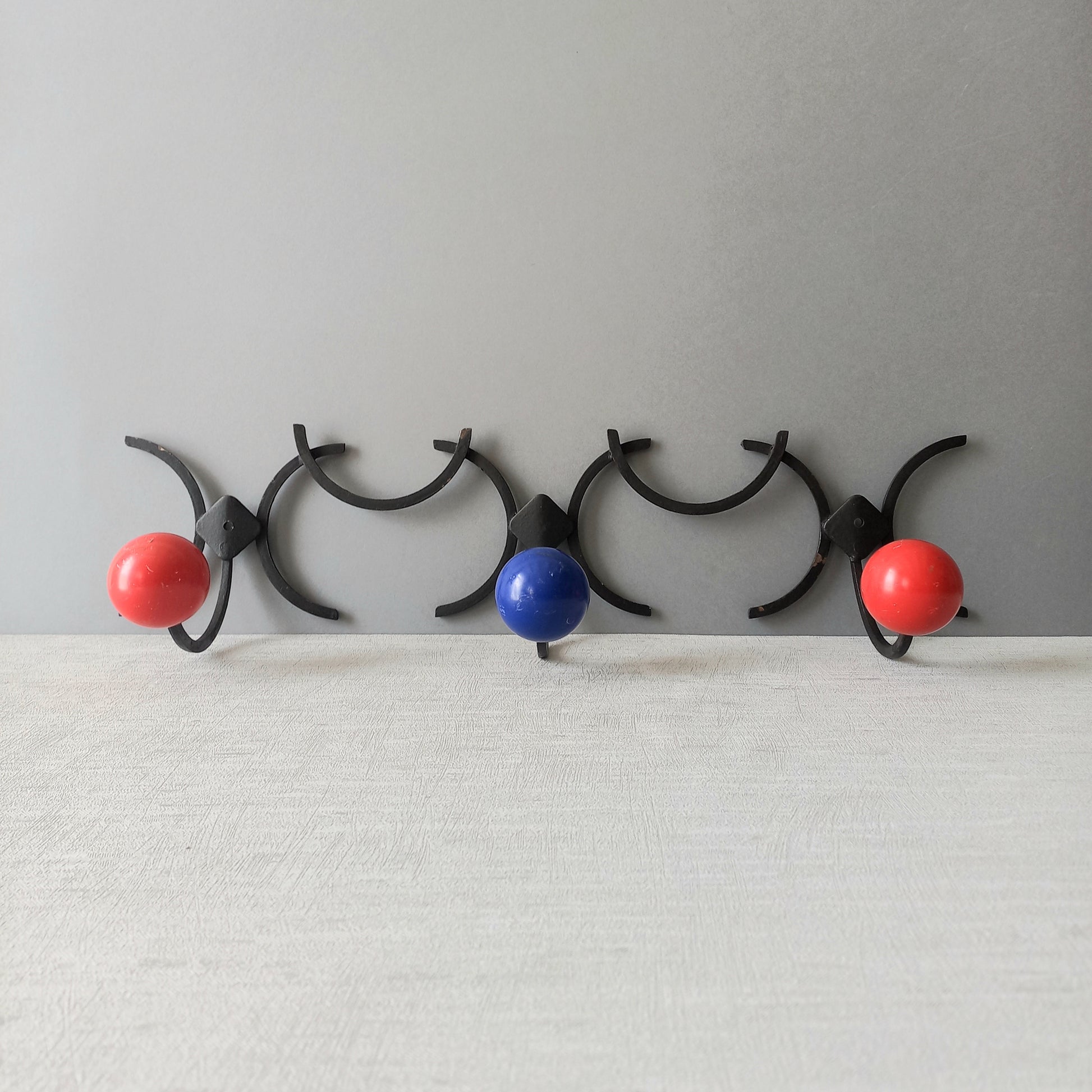 An original French vintage mid-century 'atomic' coat rack, a rare find these days and a wonderful piece of practical home decor. The black frame-work that holds the coloured pegs/balls is made from strong cast iron and there are two screw holes so that you can immediately fix the coat rack to your wall.