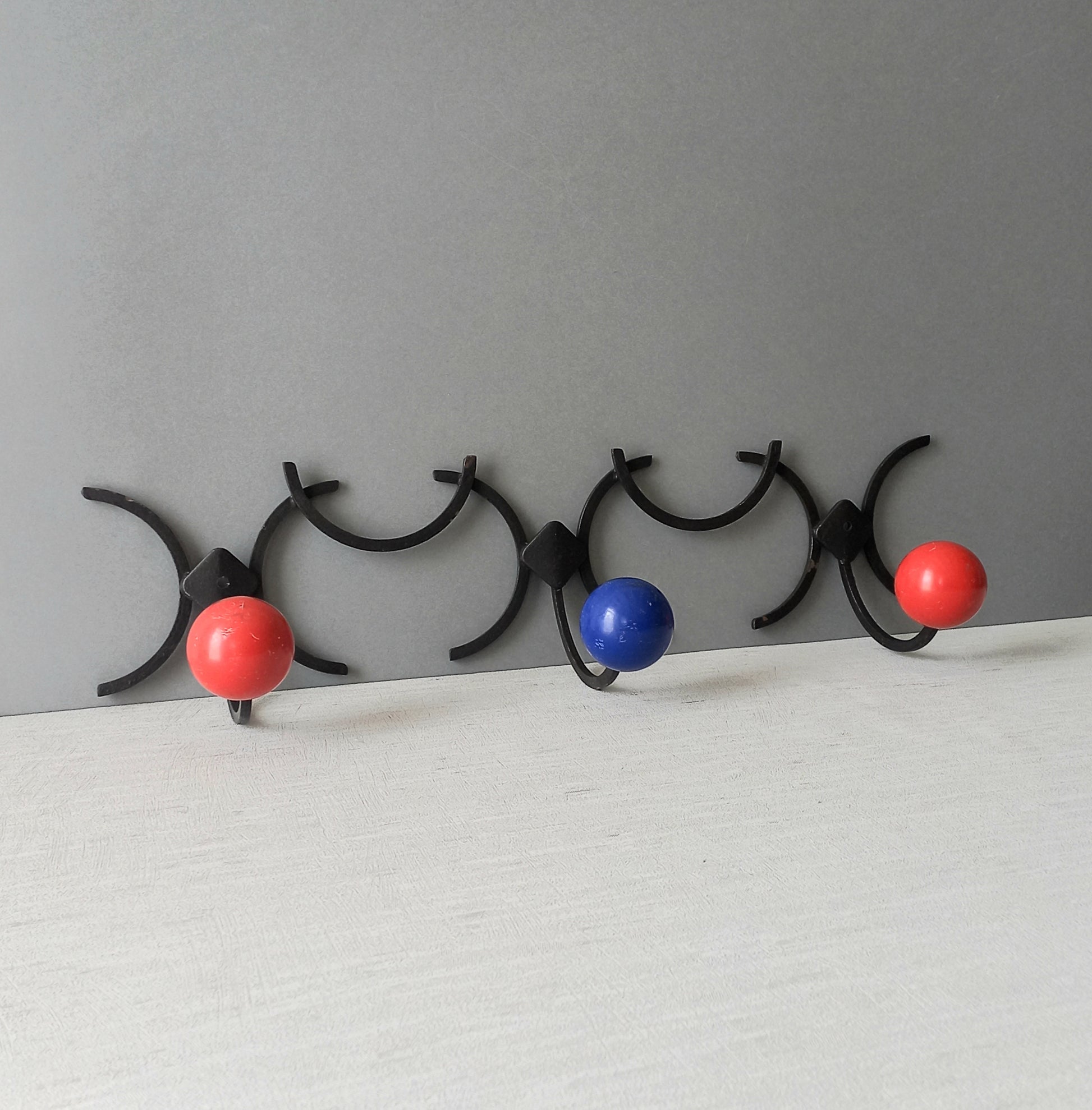 An original French vintage mid-century 'atomic' coat rack, a rare find these days and a wonderful piece of practical home decor. The black frame-work that holds the coloured pegs/balls is made from strong cast iron and there are two screw holes so that you can immediately fix the coat rack to your wall.