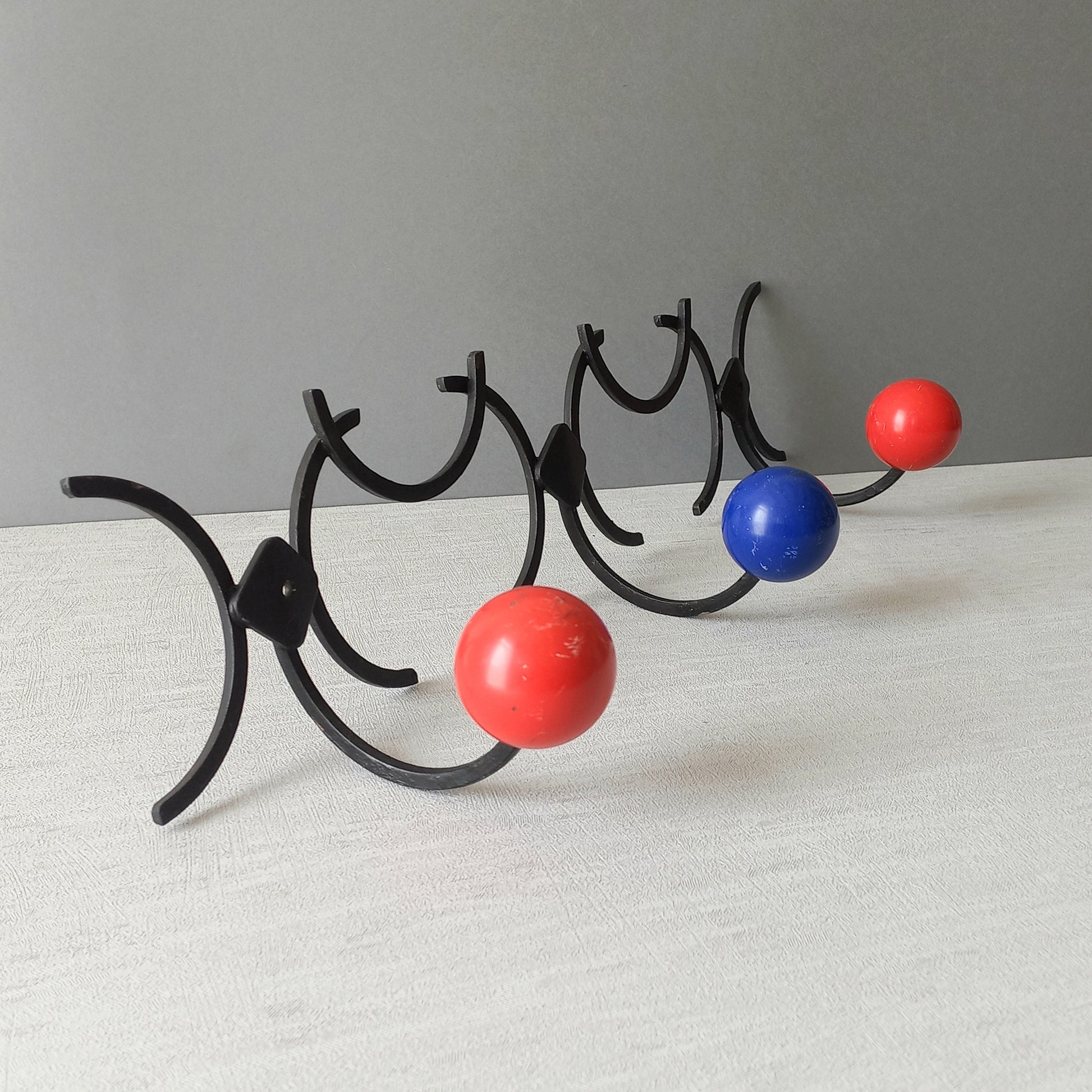 An original French vintage mid-century 'atomic' coat rack, a rare find these days and a wonderful piece of practical home decor. The black frame-work that holds the coloured pegs/balls is made from strong cast iron and there are two screw holes so that you can immediately fix the coat rack to your wall.