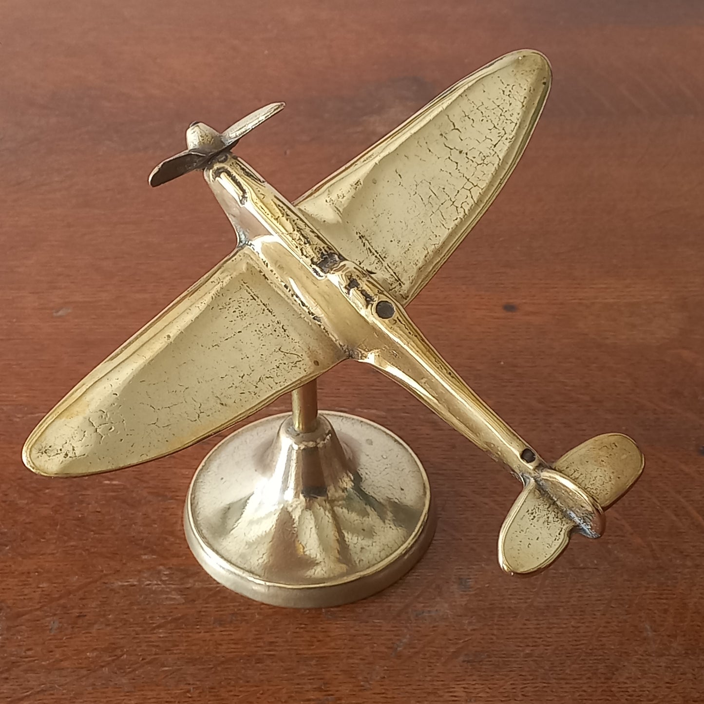 Gold airplane model on a wooden surface