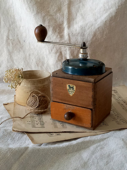 Vintage wooden coffee grinder on a textured surface with a rustic background