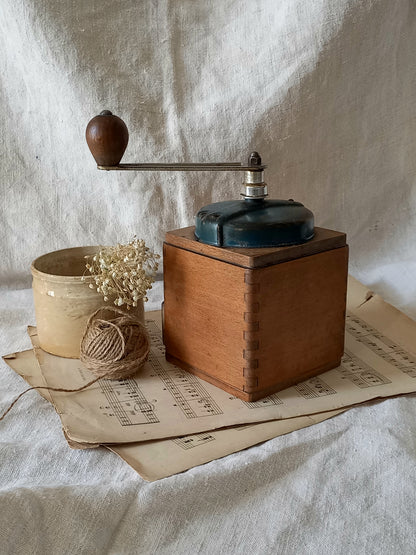 Vintage wooden coffee grinder on a textured surface with a rustic background