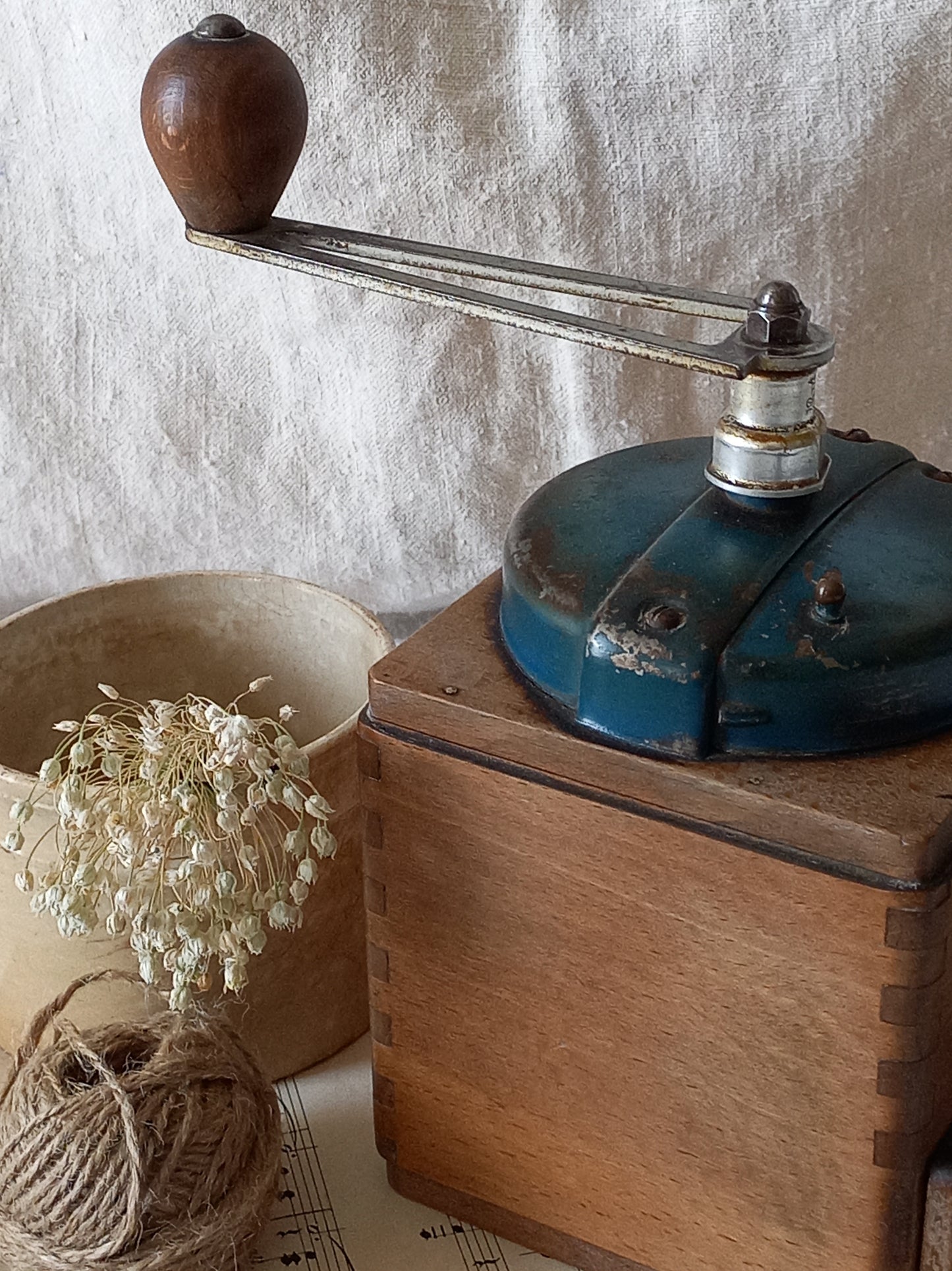 Vintage coffee grinder on a wooden base with a rustic background