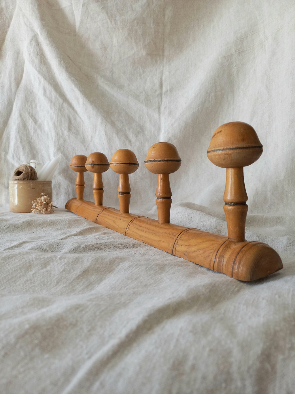 Wooden coat rack on a textured fabric background