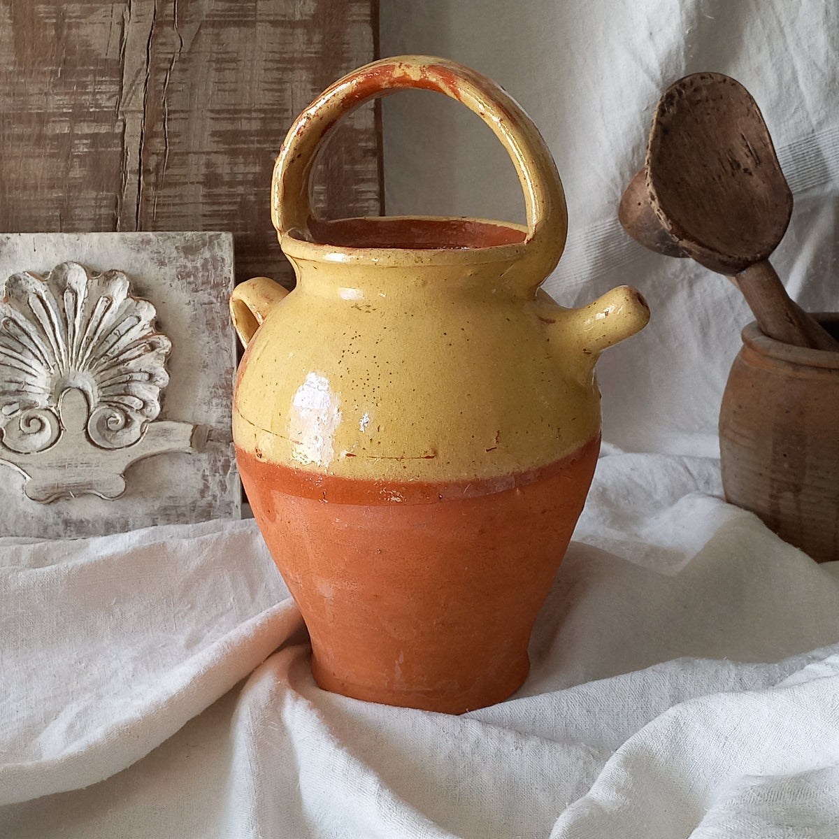 French vintage pottery jug also known as a gargoulette. The bottom half is terracotta while the upper half has a glazed yellow finish. 