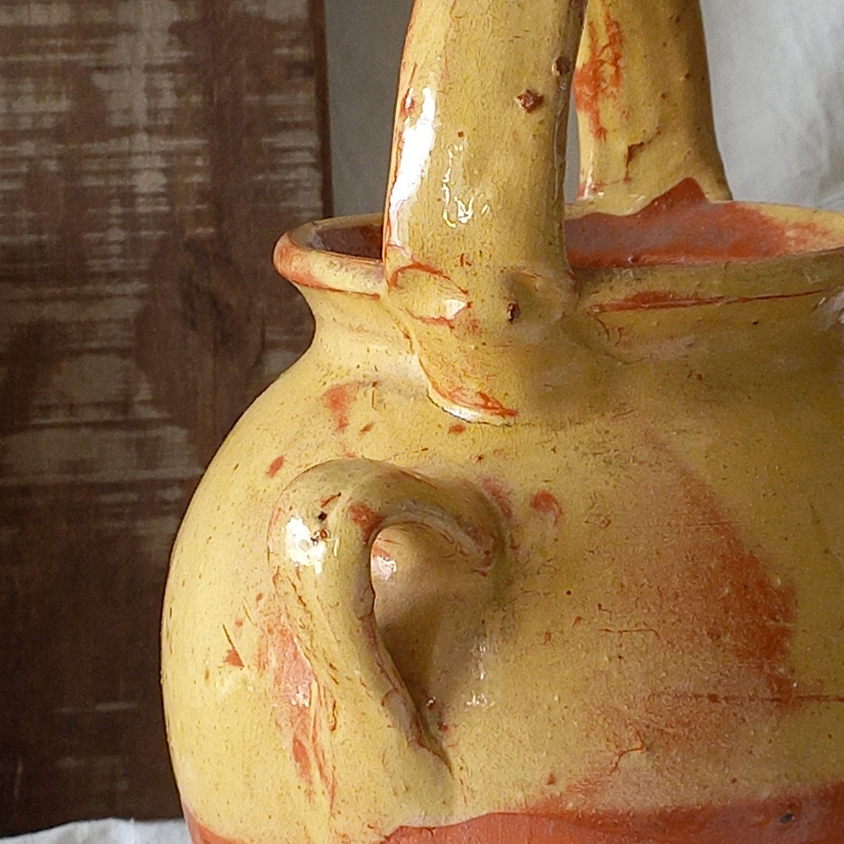 French vintage pottery jug also known as a gargoulette. The bottom half is terracotta while the upper half has a glazed yellow finish. 