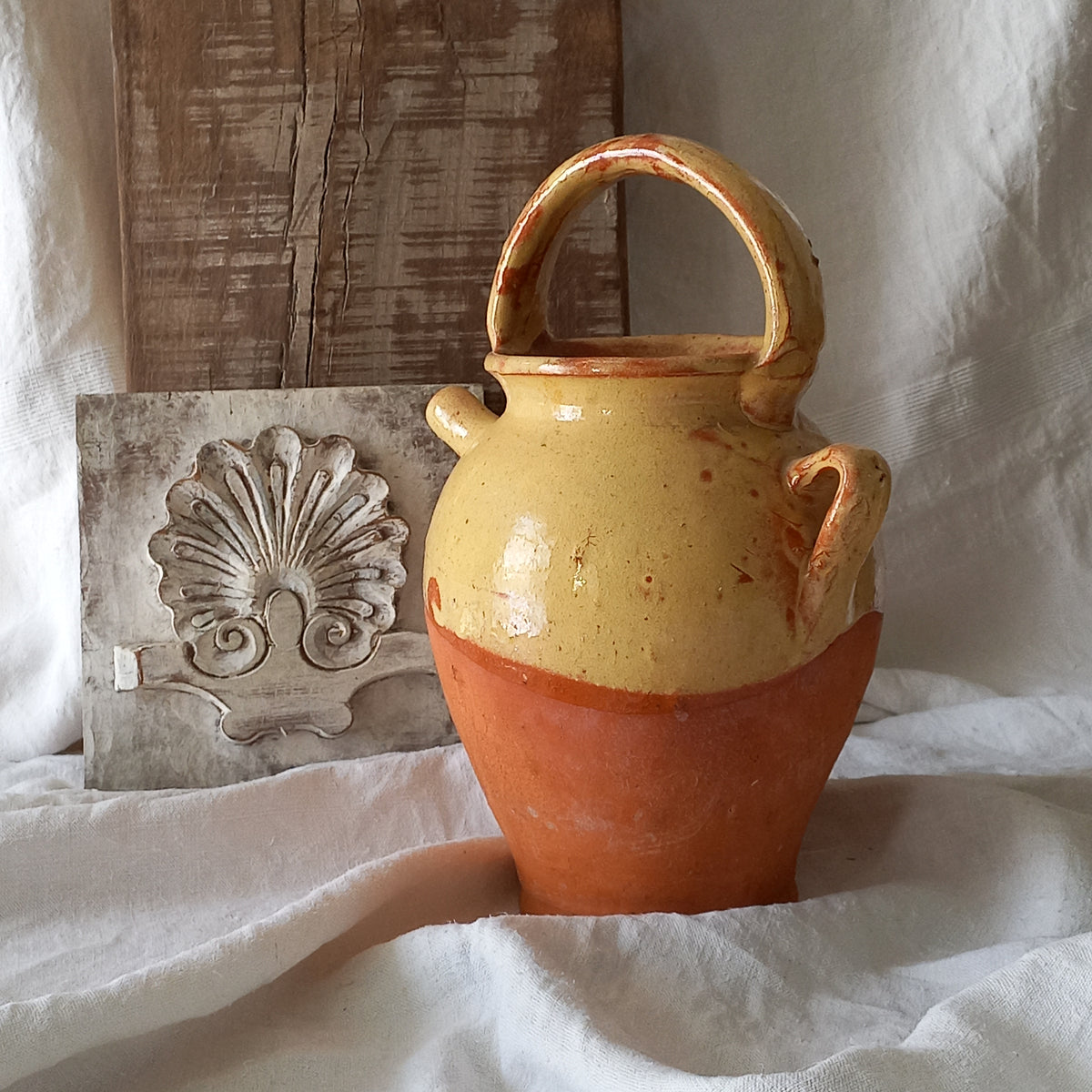 French vintage pottery jug also known as a gargoulette. The bottom half is terracotta while the upper half has a glazed yellow finish. 