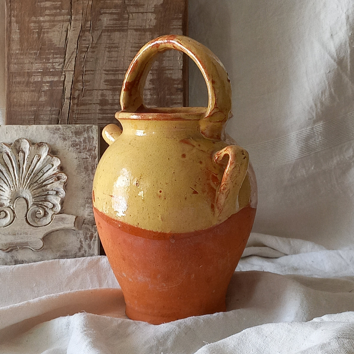 French vintage pottery jug also known as a gargoulette. The bottom half is terracotta while the upper half has a glazed yellow finish. 