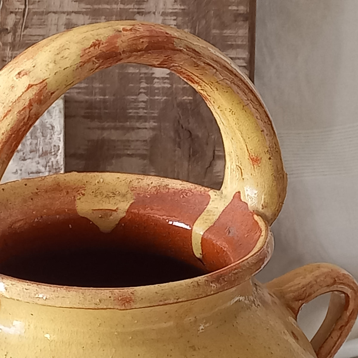 French vintage pottery jug also known as a gargoulette. The bottom half is terracotta while the upper half has a glazed yellow finish. 