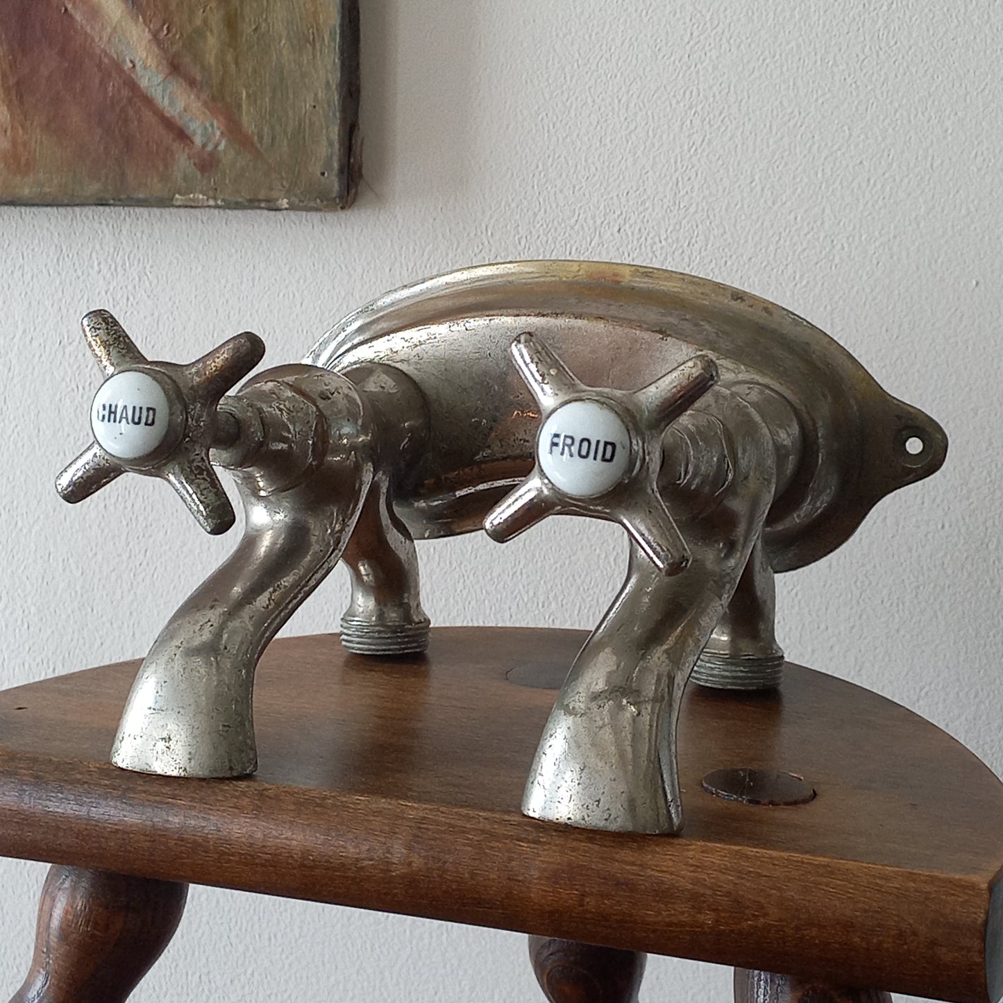 Close-up of a vintage-style faucet with wooden handle on a plain background