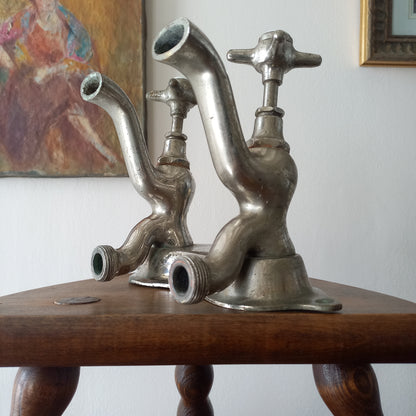 Metallic faucet-like object attached to a wooden stand with a blurred background