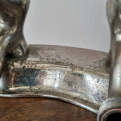 Close-up of a vintage metal faucet on a wooden background with visible wear and tear 