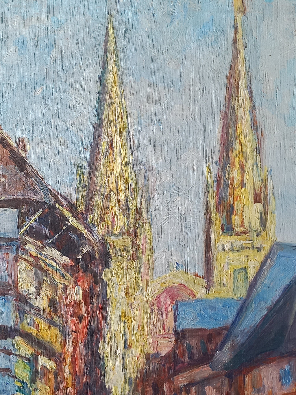 An impressionistic oil painting detail showing a pale blue sky area, yellow and gold cathedral spires, and dark blue and brown architectural shapes with thick brushstrokes.
