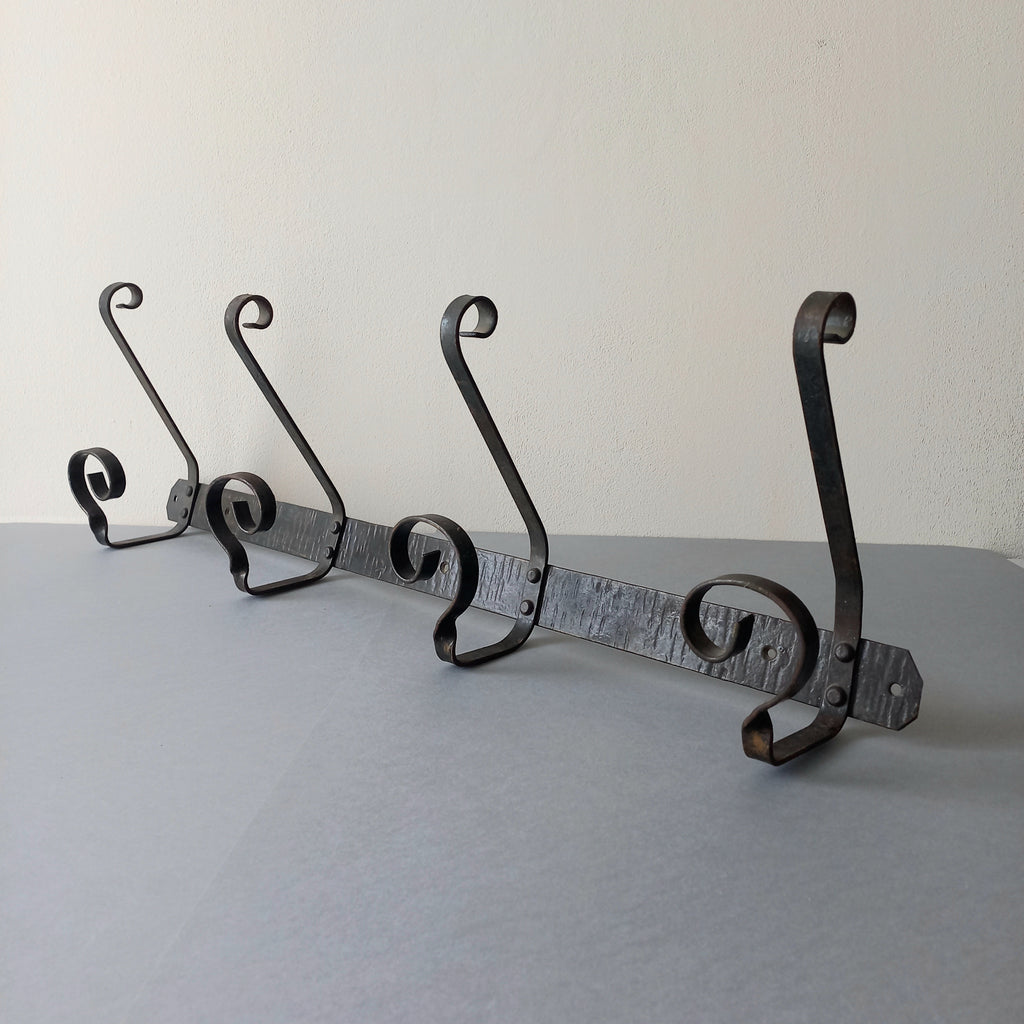 A large French vintage metal coat and hat rack for 4 coats and hats, a hand-made piece that is sturdy and can be screwed directly to your wall using the holes already in the wall bracket. The colour of the coat rack is a pleasing worn satin black with traces of gold showing through in places which give it a nice aged appearance.