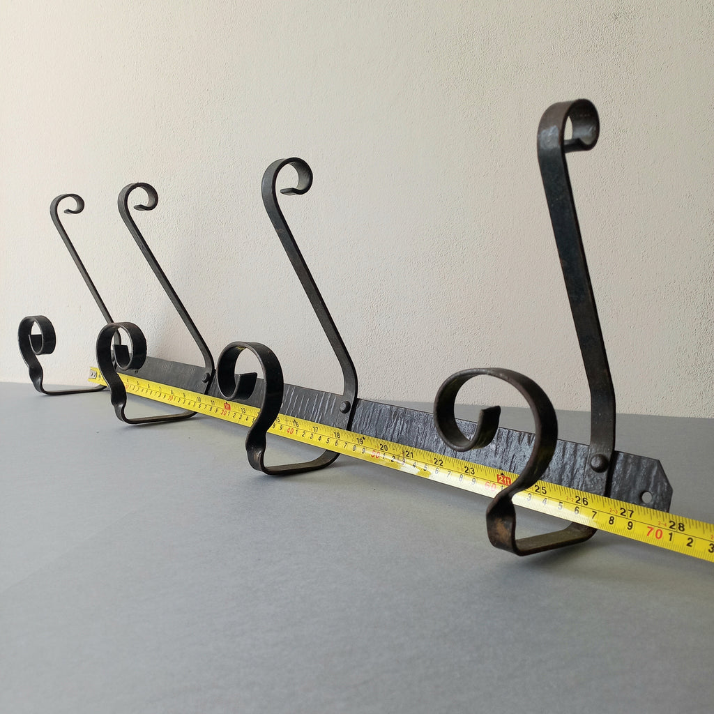 A large French vintage metal coat and hat rack for 4 coats and hats, a hand-made piece that is sturdy and can be screwed directly to your wall using the holes already in the wall bracket. The colour of the coat rack is a pleasing worn satin black with traces of gold showing through in places which give it a nice aged appearance.