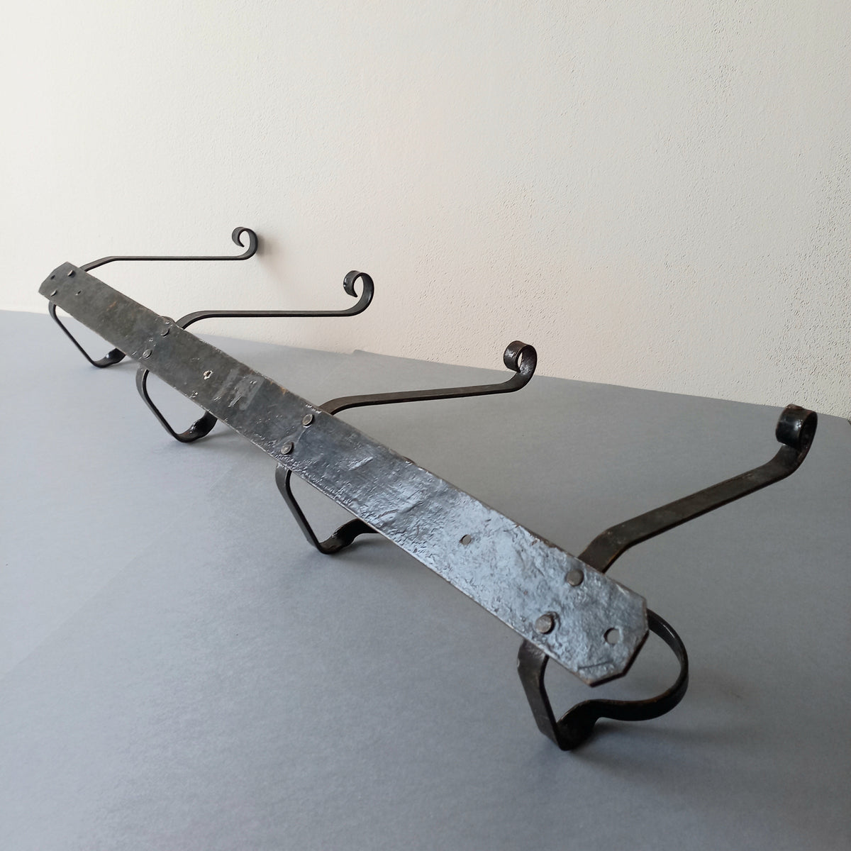 A large French vintage metal coat and hat rack for 4 coats and hats, a hand-made piece that is sturdy and can be screwed directly to your wall using the holes already in the wall bracket. The colour of the coat rack is a pleasing worn satin black with traces of gold showing through in places which give it a nice aged appearance.