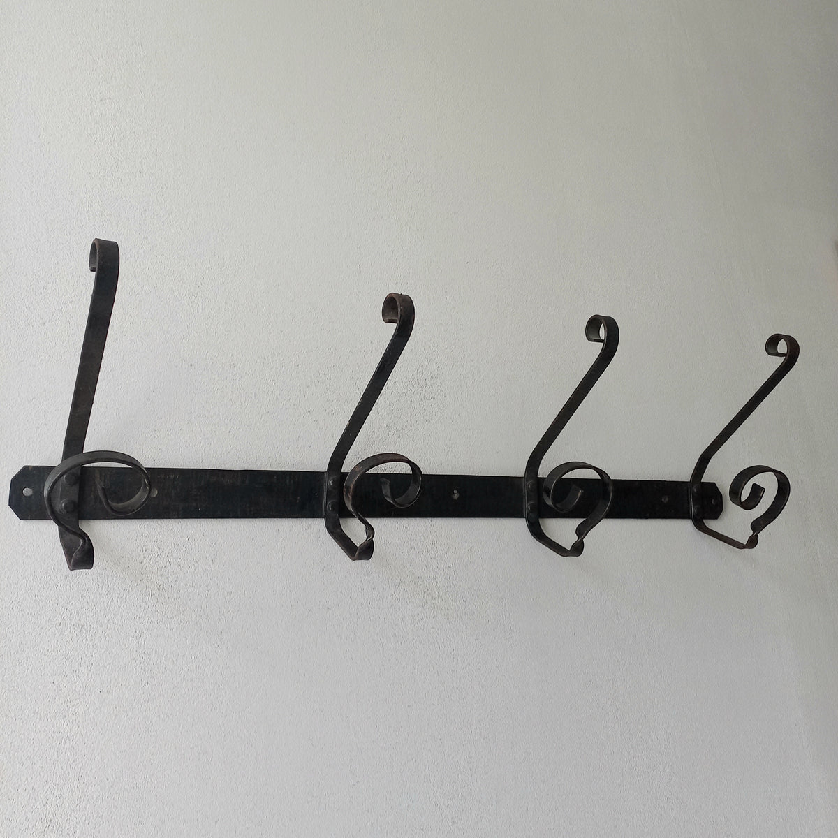 A large French vintage metal coat and hat rack for 4 coats and hats, a hand-made piece that is sturdy and can be screwed directly to your wall using the holes already in the wall bracket. The colour of the coat rack is a pleasing worn satin black with traces of gold showing through in places which give it a nice aged appearance.