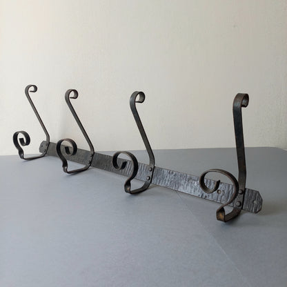 A large French vintage metal coat and hat rack for 4 coats and hats, a hand-made piece that is sturdy and can be screwed directly to your wall using the holes already in the wall bracket. The colour of the coat rack is a pleasing worn satin black with traces of gold showing through in places which give it a nice aged appearance.