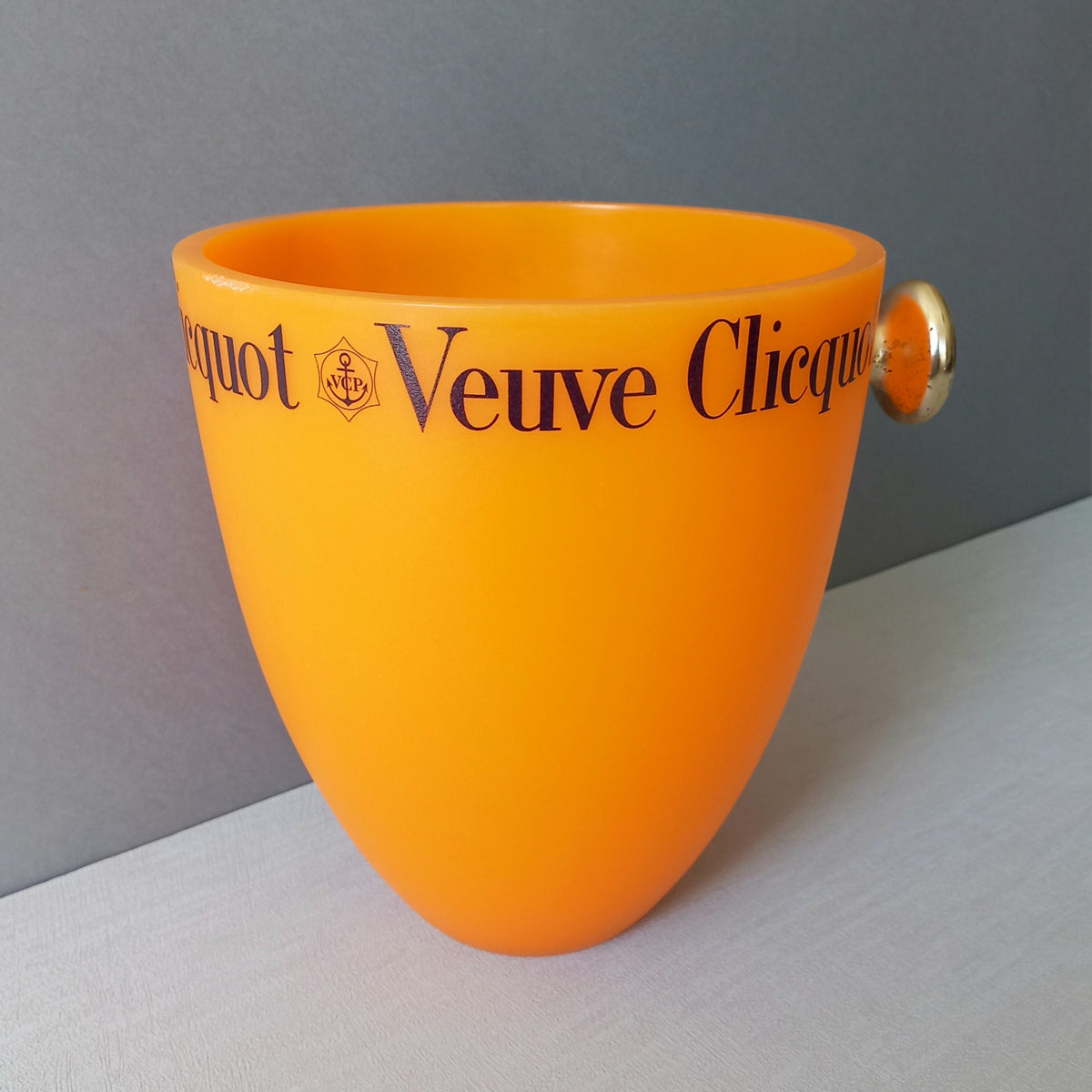 A French vintage Veuve Clicquot thick plastic champagne cooler in a wonderful shade of vibrant yellow-orange. Veuve Clicquot are from Reims, France (founded in 1772) and is one of the premier champagne manufacturers in the world so this piece will serve as a nice practical collectible.