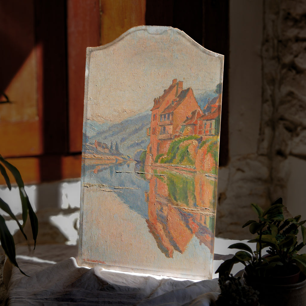 An original vintage oil painting depicting a village on the banks of a large river. It looks similar to the Rhine River Danube in Germany, and with the large hills/mountains in the background maybe the Black Forest, although it could be many places in Europe and perhaps even in France where we purchased this wonderful piece of original art on wooden board.