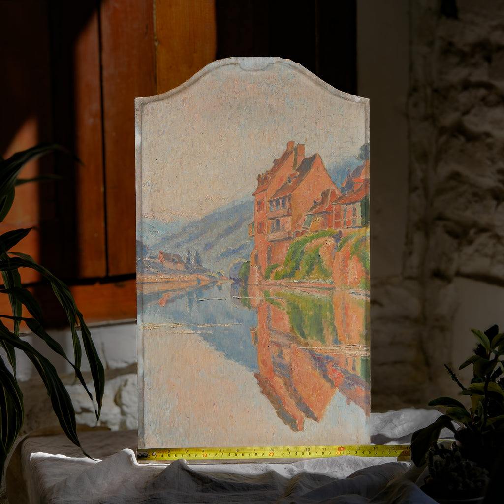 An original vintage oil painting depicting a village on the banks of a large river. It looks similar to the Rhine River Danube in Germany, and with the large hills/mountains in the background maybe the Black Forest, although it could be many places in Europe and perhaps even in France where we purchased this wonderful piece of original art on wooden board.
