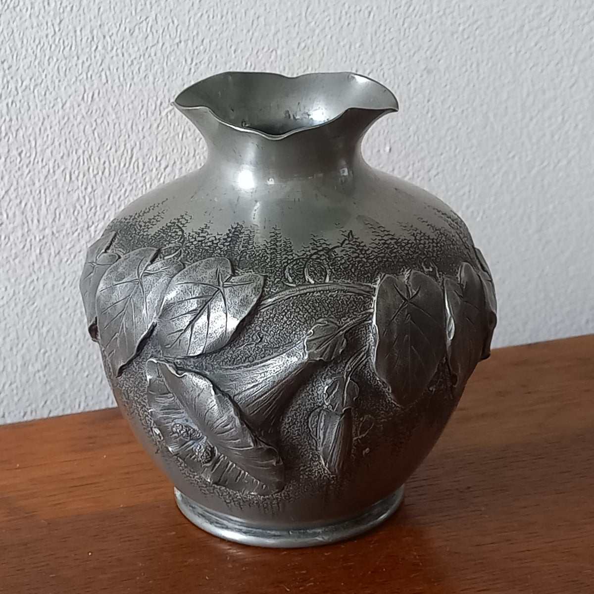 A stunning little French vintage pewter pot/vase, a highly decorative art piece with floral sculptures in relief. This beautiful little piece of art has been signed by the artist.