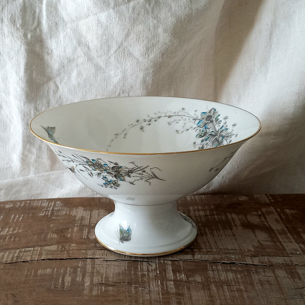 Stunning vintage porcelain compote purchased in south west France.

This beautiful piece is a quality 'footed' fruit bowl with a good weight and absolutely gorgeous floral and butterfly decoration with hand-painted details in relief.