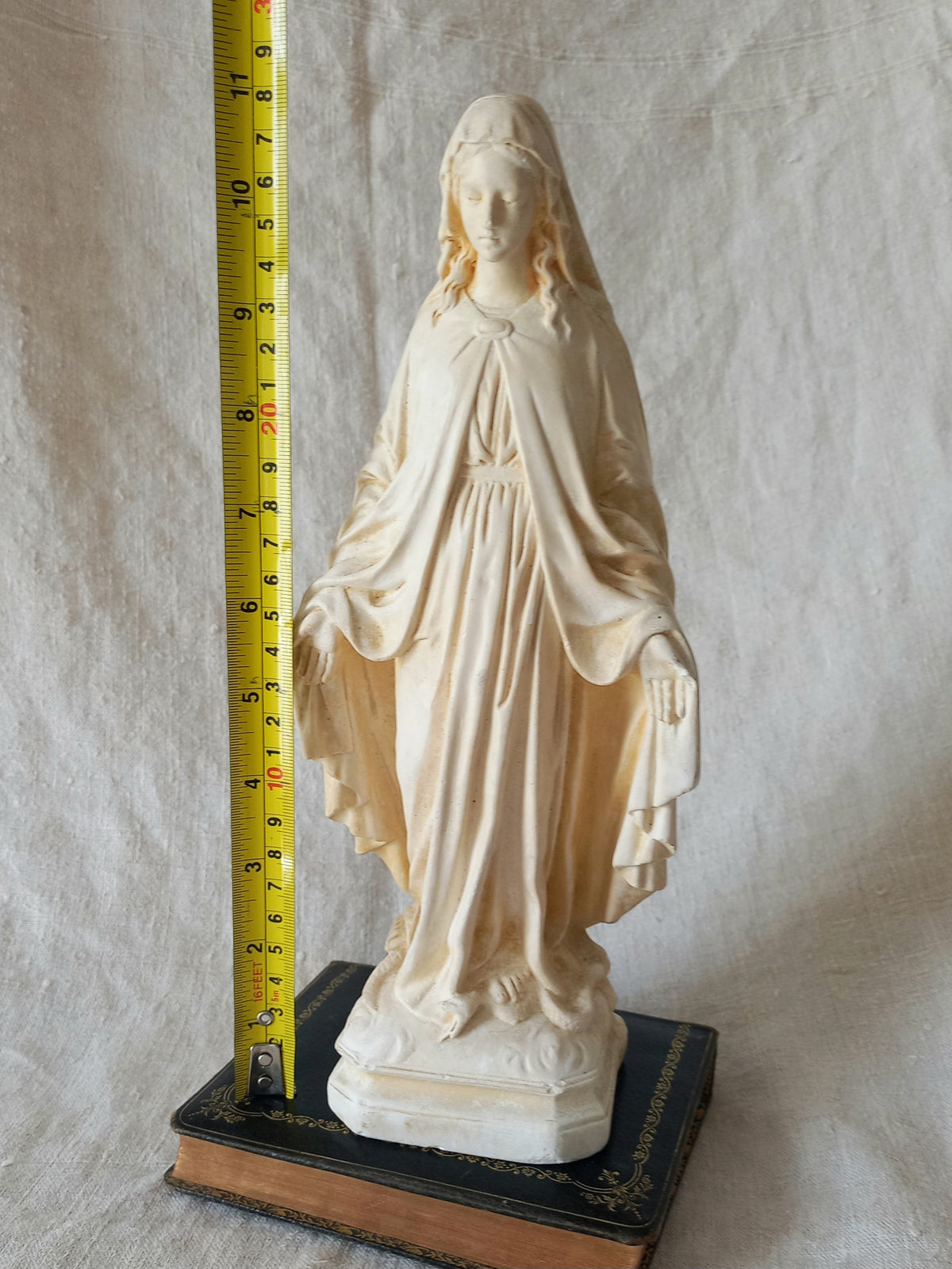 French vintage religious Madonna figurine made from plaster with a tape measure for reference.