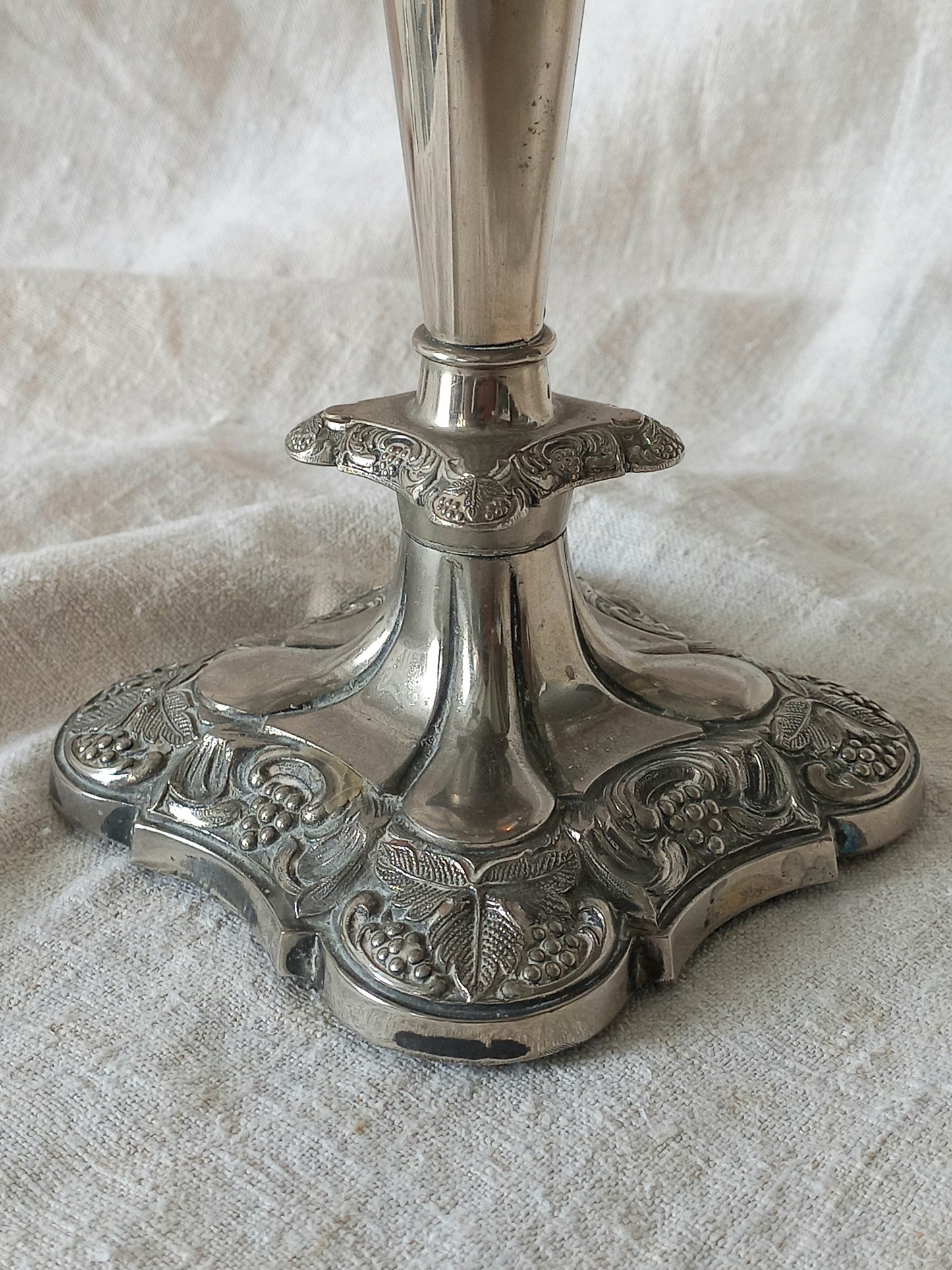 Decorative silver candlestick on a textured white fabric background