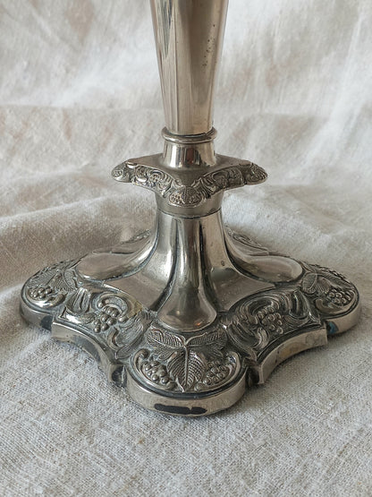 Decorative silver candlestick on a textured white fabric background