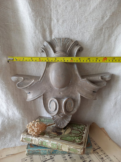 A French antique decorative carved wooden pediment that has been tastefully painted and worn to give an attractive shabby chic finish.